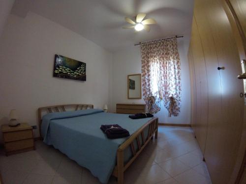 a bedroom with a blue bed and a window at Casa Vacanze La Vite in Stintino
