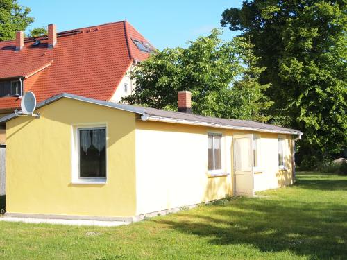 ein kleines gelbes und weißes Haus in einem Hof in der Unterkunft Meerzauber in Altenkirchen