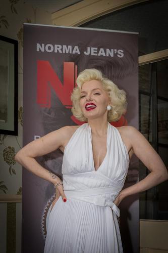 a woman in a white dress standing in front of a sign at The Sandringham Court Hotel & Apartment Welcoming Large and Small Groups for 16 years in Blackpool