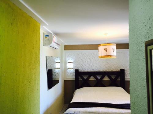 um quarto com uma cama e uma parede amarela em Pousada Acgua Residenz em Cabo de Santo Agostinho