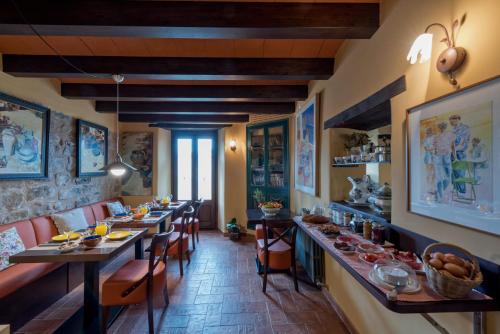 uma longa sala de jantar com mesas e cadeiras longas em Hotel Cal Sastre em Santa Pau