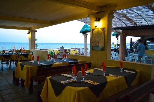 dos mesas en un restaurante con el océano en el fondo en Hotel Costa Jonica, en Sellia Marina