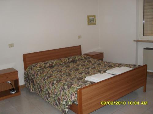 ein Schlafzimmer mit einem Bett mit einem Bettrahmen aus Holz in der Unterkunft residence la collinetta in Cagli