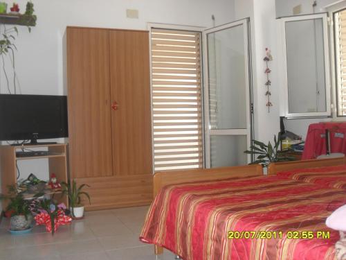 a bedroom with a bed and a flat screen tv at residence la collinetta in Cagli