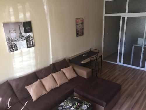 a living room with a brown couch and a table at Pirotska Apartment GN / FREE GARAGE in Sofia