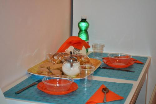 una mesa con platos y tazones de comida. en Amarfia Bed & Breakfast - Your Home In Salerno, en Salerno