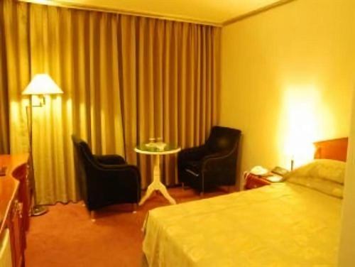 une chambre d'hôtel avec un lit, deux chaises et une table dans l'établissement Hotel The Palace Daegu, à Daegu