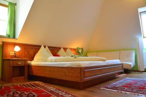 a bedroom with a large wooden bed with pillows at Gästehaus Turm Wachau in Weissenkirchen in der Wachau
