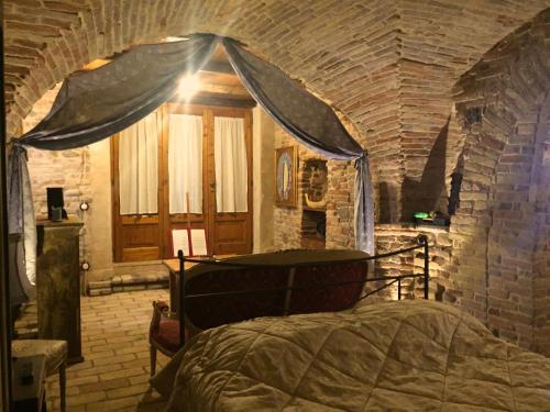 1 dormitorio con 1 cama en una pared de ladrillo en Pantorano rooms, en Spinetoli