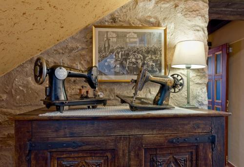 a room with two antique sewing machines on a table at Hotel Cal Sastre in Santa Pau