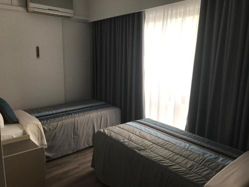 a hotel room with two beds and a window at Hotel do Parque in Viana do Castelo