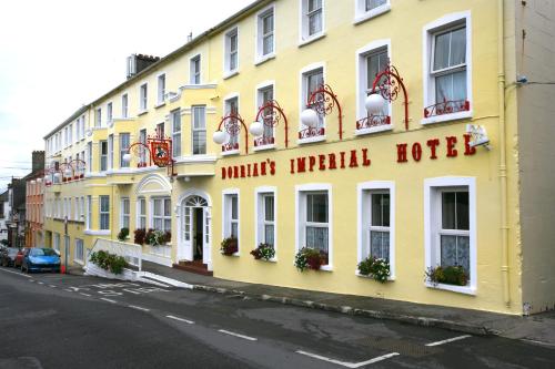 ein gelbes Gebäude mit einem Hotel in einer Straße in der Unterkunft Dorrians Imperial Hotel in Ballyshannon