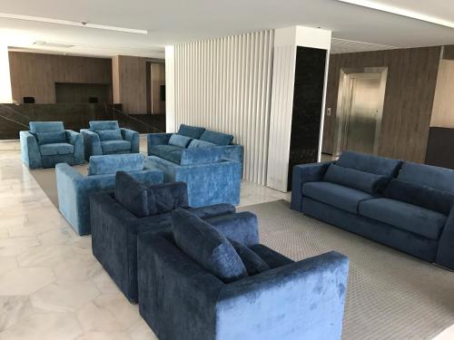 a living room with blue couches and blue chairs at Hotel do Parque in Viana do Castelo