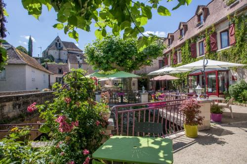 a patio with tables and umbrellas and flowers at Logis Hotels - Auberge de l'Île - Hôtel 3 étoiles et Restaurant in Creysse