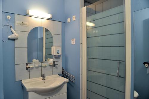 La salle de bains est pourvue d'un lavabo et d'un miroir. dans l'établissement Logis Hôtel Le Val de Vence, à Launois-sur-Vence