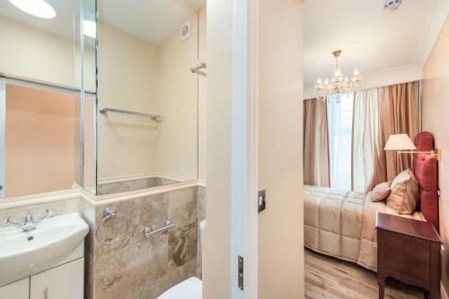 a bathroom with a sink and a shower and a bed at London Residence in London