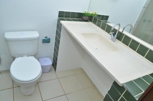 a bathroom with a toilet and a sink at Hotel Pousada Summer Way in Aquiraz