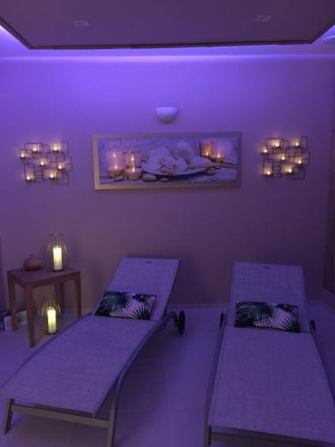 two purple beds in a purple room with lights at Aux 5 Sens in Tillé