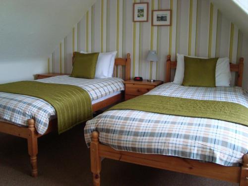 twee bedden naast elkaar in een kamer bij Willowbank in Grantown on Spey