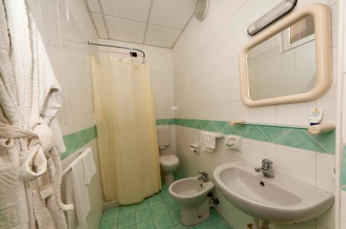 a bathroom with a sink and a toilet and a mirror at Hotel Villa Franca in Ischia