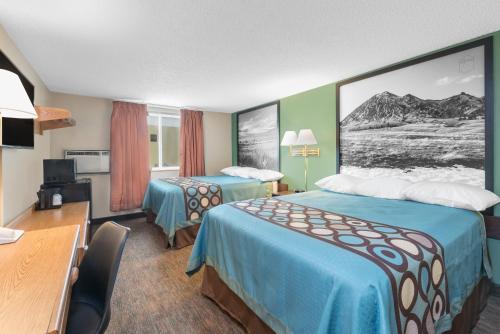 um quarto de hotel com duas camas e uma secretária em Super 8 by Wyndham Pierre SD em Pierre