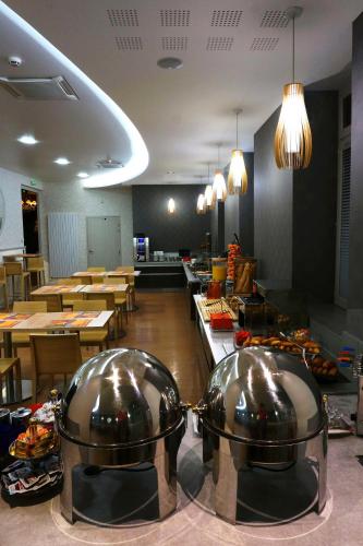 a restaurant with two large metal domes on a counter at LOGIS Hôtel de Bourgogne - Mâcon in Mâcon