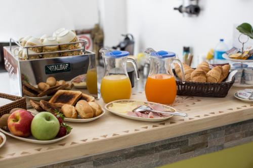 a table topped with plates of food and orange juice at Relais Villa Anna in Anacapri