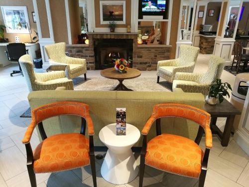 a lobby with chairs and a table and a fireplace at The Wilshire Grand Hotel in West Orange