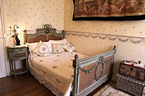 a bedroom with a bed and a lamp and a table at Chateau du Mur in Comblessac