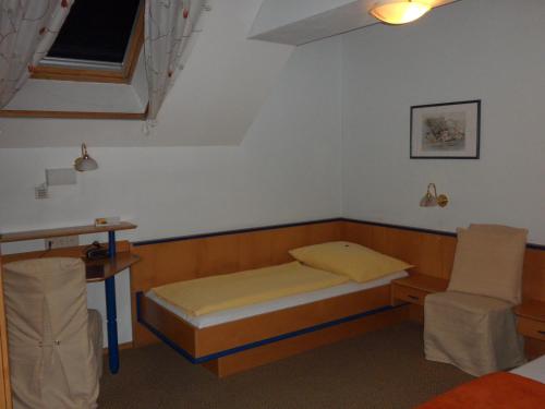 a small room with a bed and a chair at Frühstückspension Barbara in Pöchlarn