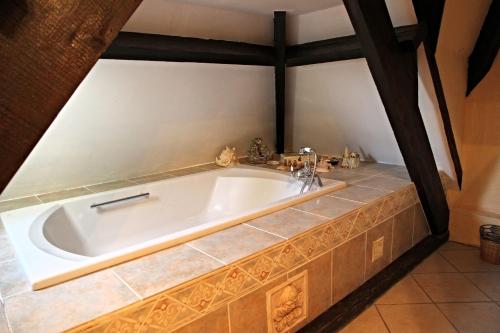 a bath tub in a bathroom with a tile floor at Chateau du Mur in Comblessac