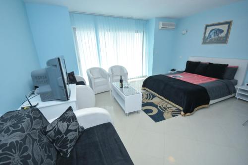a bedroom with a bed and a tv in it at Hotel Oaza in Budva