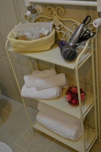a shelf with towels and a hairdryer on it at Tucci's Roma Guest House in Rome