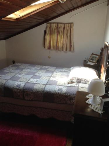 a bedroom with a bed and a table with a lamp at Casa da Avó in Geres