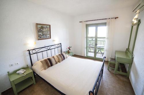 - une chambre avec un grand lit et une fenêtre dans l'établissement Elpida Village, à Istron