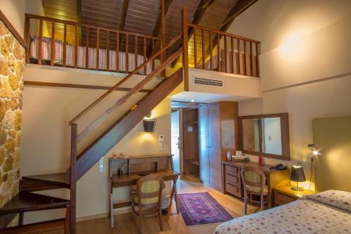 sypialnia ze schodami, biurkiem i łóżkiem w obiekcie Orizontes Tzoumerkon Hotel Resort w mieście Pramanta