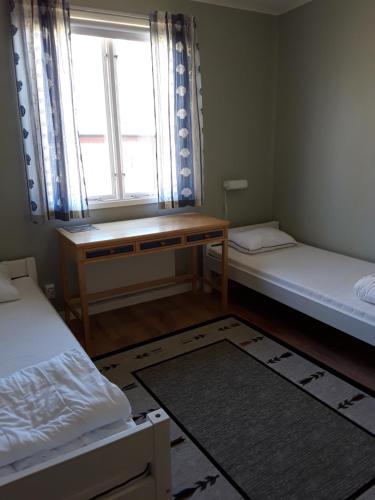 a room with two beds and a desk and a window at Stegeborgsgården in Norrkrog