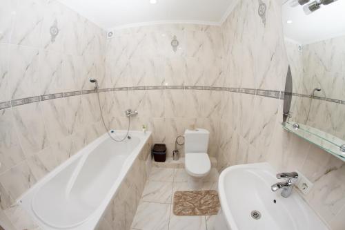 a bathroom with a tub and a toilet and a sink at Panorama Apart-Hotel in Kamianets-Podilskyi