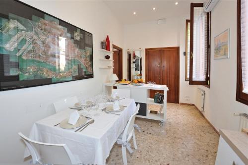 una sala da pranzo con tavolo bianco e sedie bianche di Venice San Leonardo a Venezia