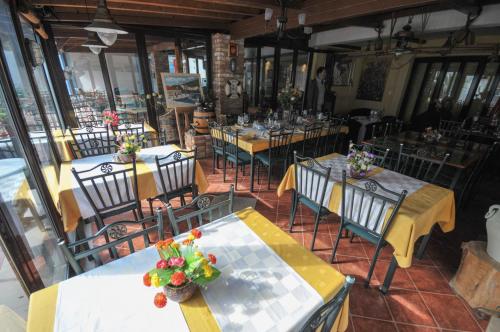 a restaurant with several tables and chairs with flowers on them at Hotel Oaza in Budva