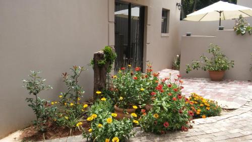 un giardino fiorito di fronte a una casa di @Home Cottage a Johannesburg