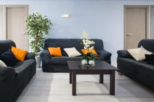 a living room with two blue couches and a coffee table at Hostal Pardo in Miami Platja