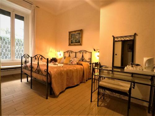 a bedroom with a bed and a table and a mirror at Tucci's Roma Guest House in Rome