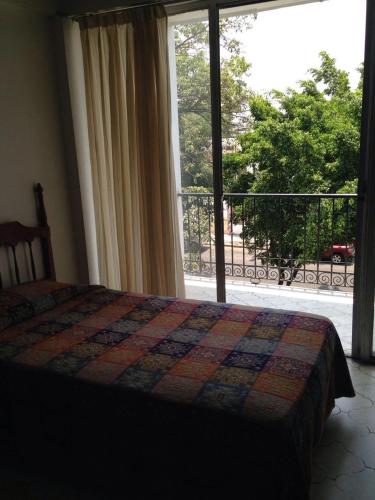1 dormitorio con cama y ventana grande en Hotel Flamingos Colima, en Colima