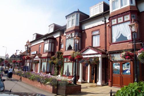 a row of houses on a city street with flowers at Revelstoke Hotel in Bridlington