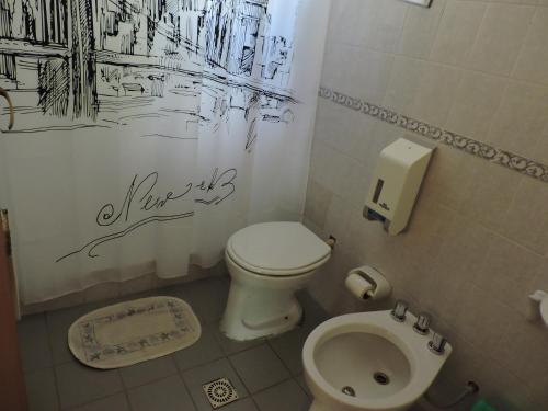 a bathroom with a toilet and a sink at Cabañas de la Colina in Villa General Belgrano