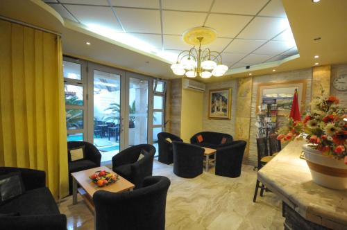 a waiting room with black chairs and a table at Hotel Oaza in Budva