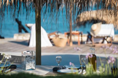 a table with plates and wine glasses on it at Golden Beach Hotel in Chrissi Akti