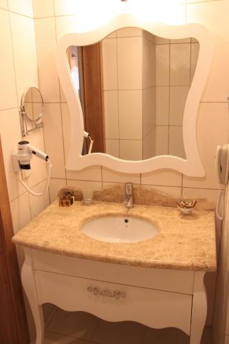 a bathroom with a sink and a mirror at Galeri Resort Hotel - Ultra All Inclusive in Okurcalar