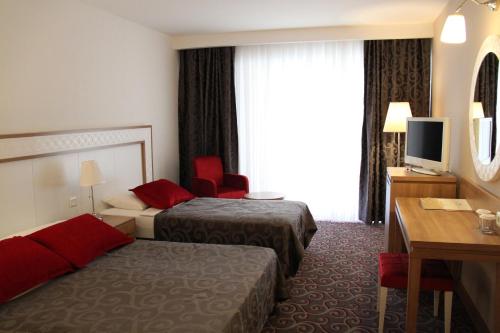a hotel room with two beds and a desk at Galeri Resort Hotel - Ultra All Inclusive in Okurcalar